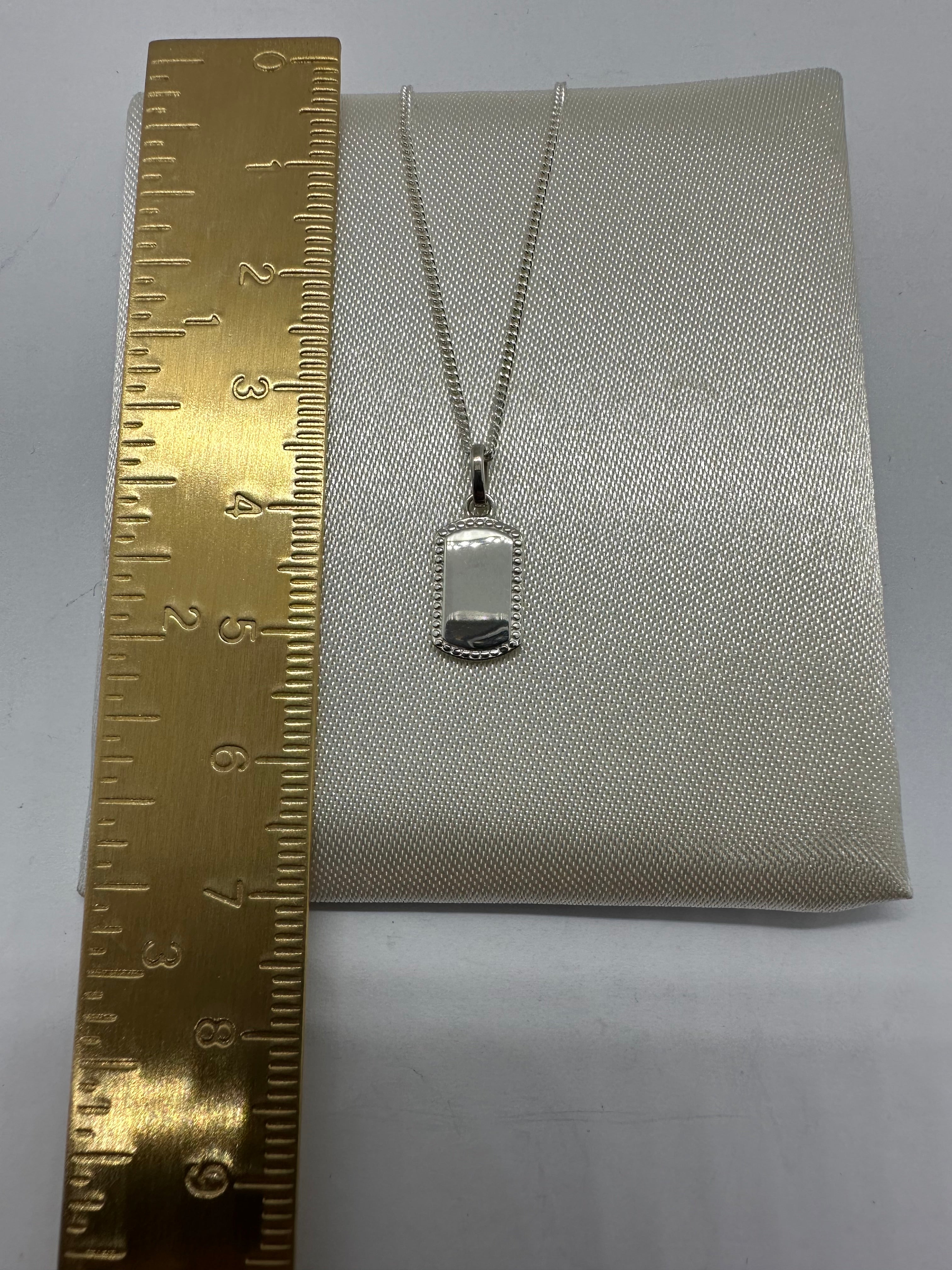 Silver rectangular beaded edge pendant